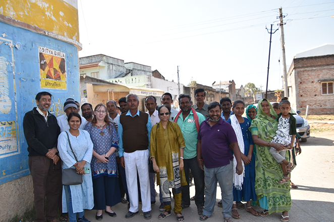 Holly Campbell-Rosen, Ph.D. stands on a side street  next to a building  alongside several Suicide Prevention & Implementation Research Initiative (SPIRIT Research Initiative (SPIRIT) team members in Mehsana, Gujarat. 
