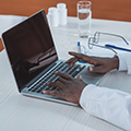 Doctor typing on a laptop computer