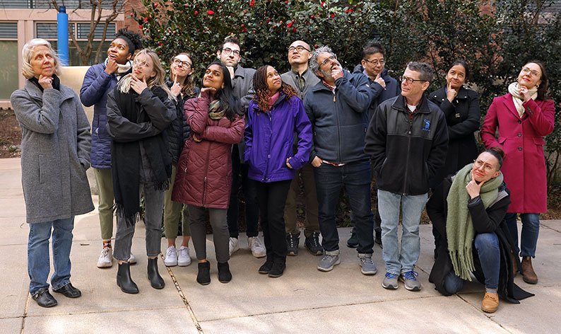 SDN staff posing for a group picture while striking a thinking pose